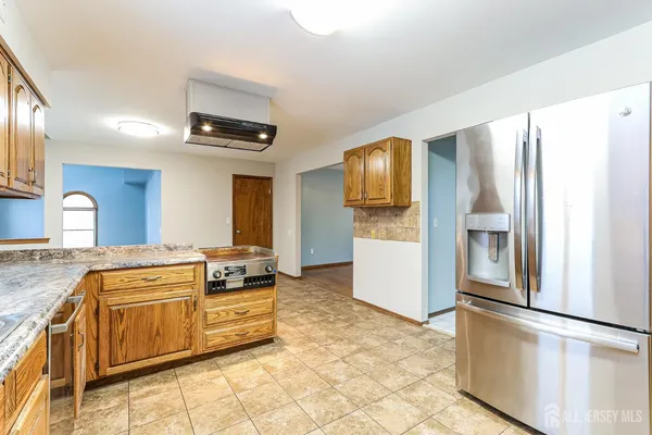 a kitchen with stainless steel appliances granite countertop a refrigerator and a stove