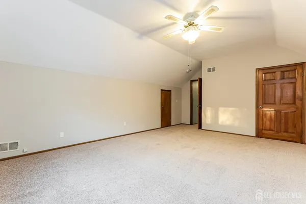 an empty room with closet and a ceiling fan