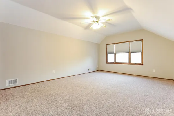 an empty room with windows and fan
