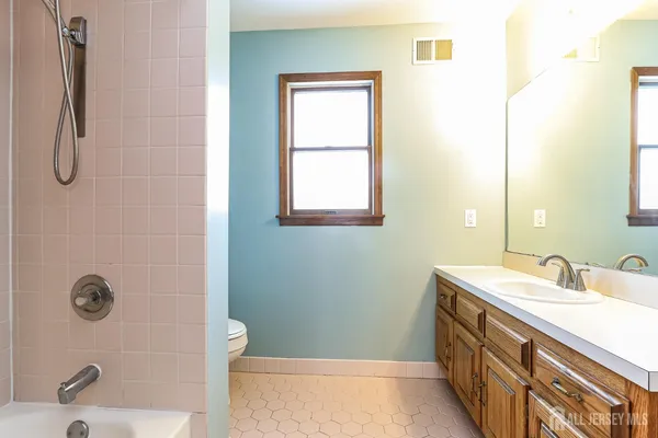 a bathroom with a granite countertop sink a toilet and shower