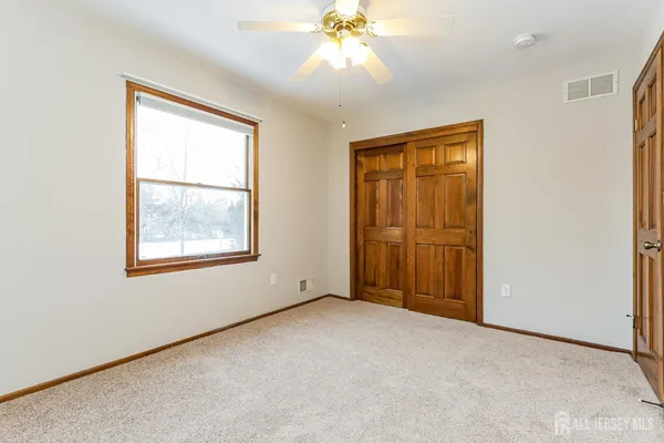 an empty room with windows and closet