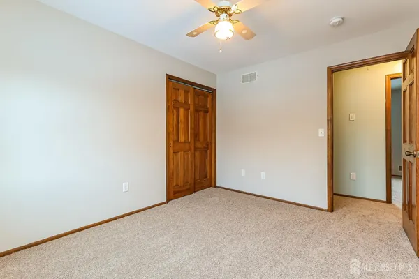 an empty room with a window and a ceiling fan