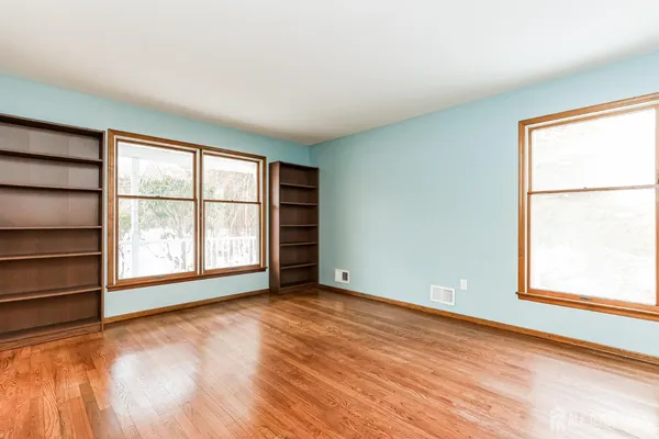 an empty room with windows and closet
