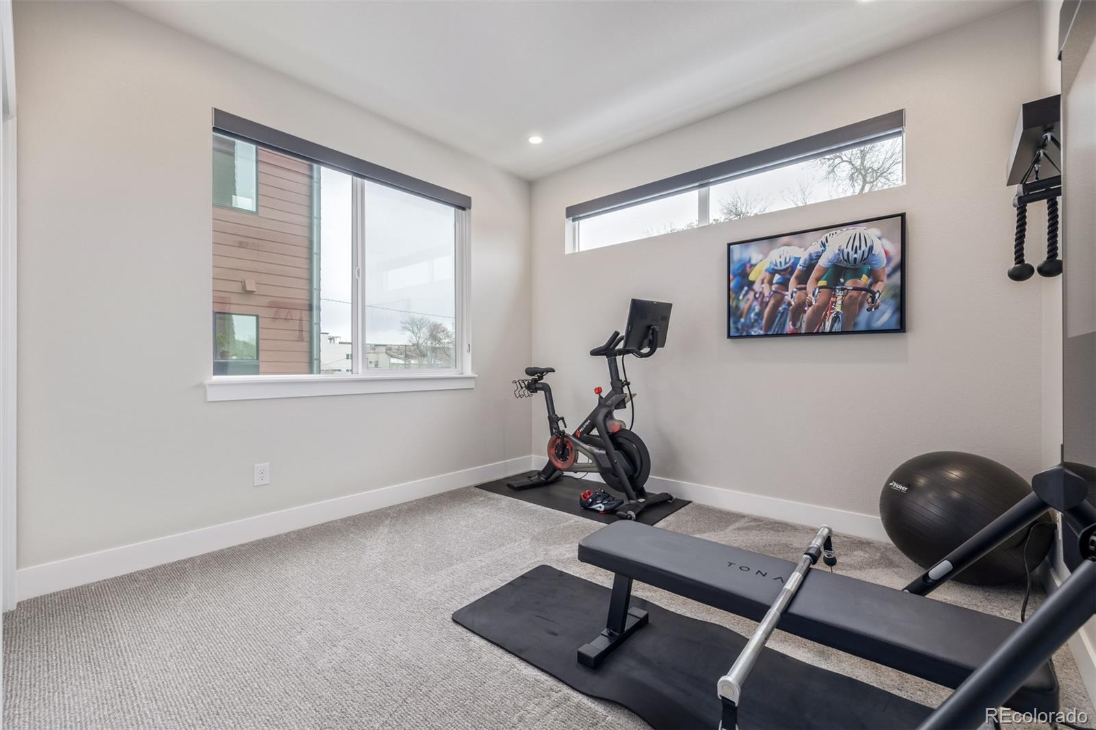 2350 Tremont Place, Unit 13 Denver, CO 80205 - Photo 14 of 41 a room with gym equipment and windows