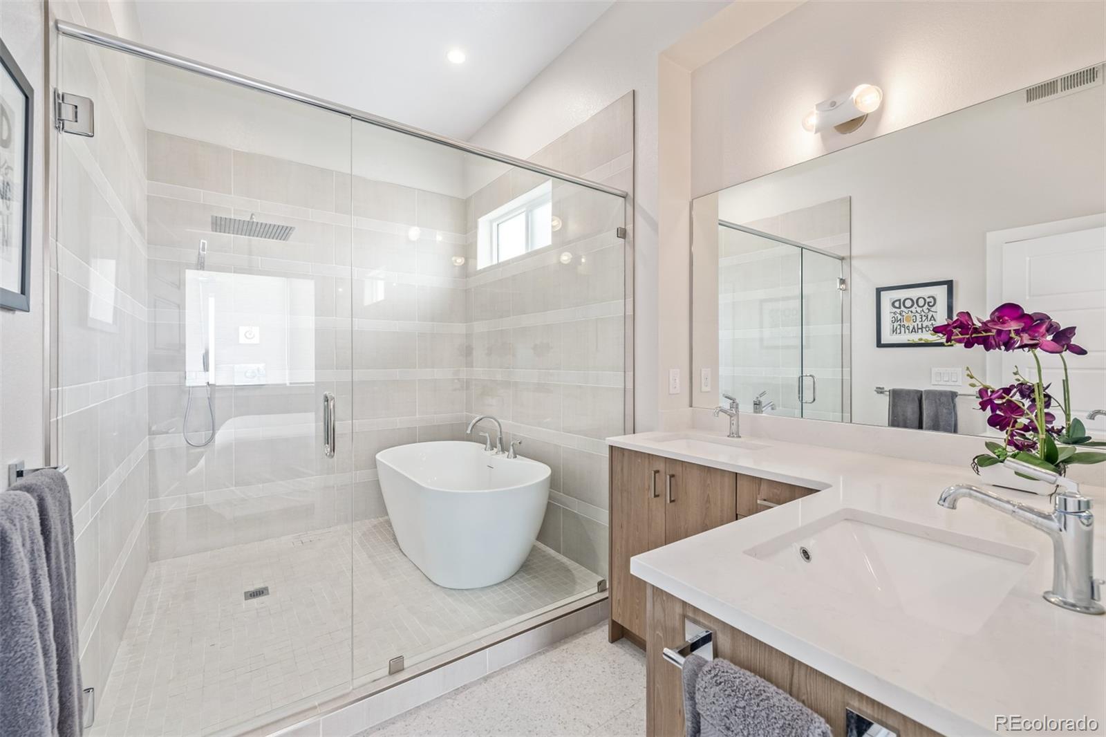 2350 Tremont Place, Unit 13 Denver, CO 80205 - Photo 24 of 41 a spacious bathroom with a sink a toilet a mirror and vanity