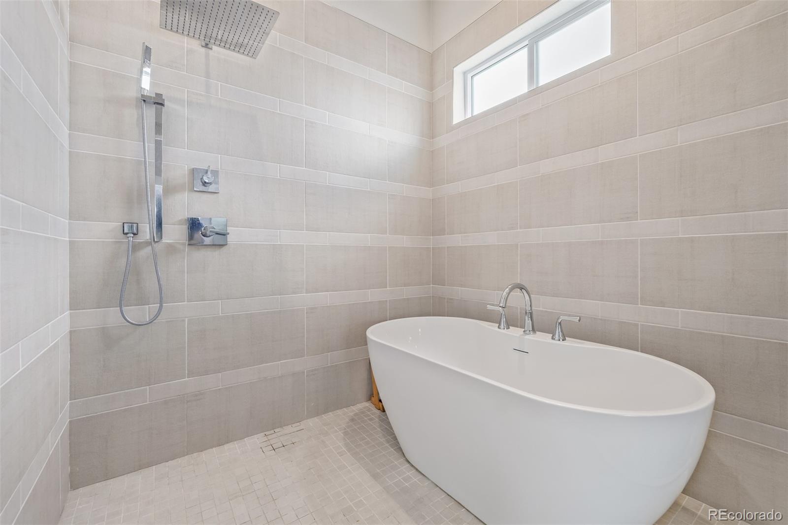 2350 Tremont Place, Unit 13 Denver, CO 80205 - Photo 25 of 41 a white bath tub sitting next to a white sink and a shower