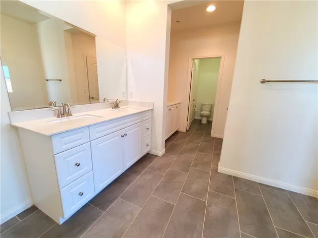 a spacious bathroom with a double vanity sink a mirror and a