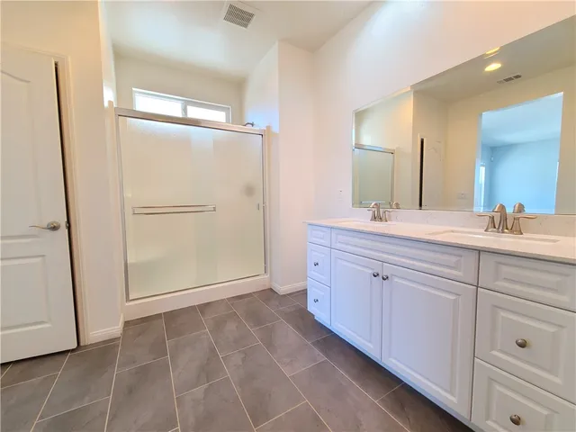a spacious bathroom with a mirror sink and shower