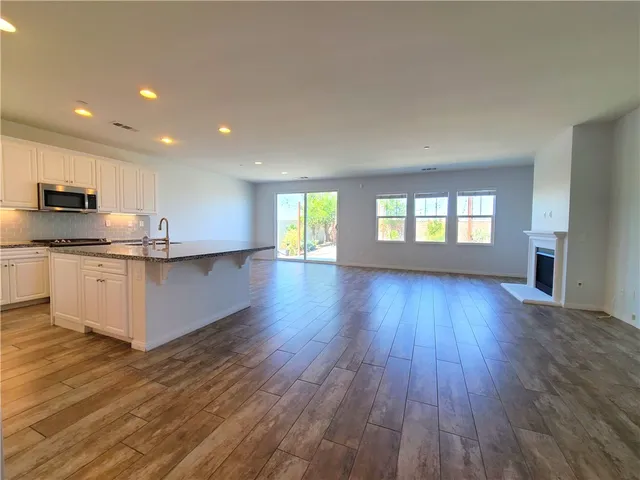 a large kitchen with hard wood floors and stainless steel appliances
