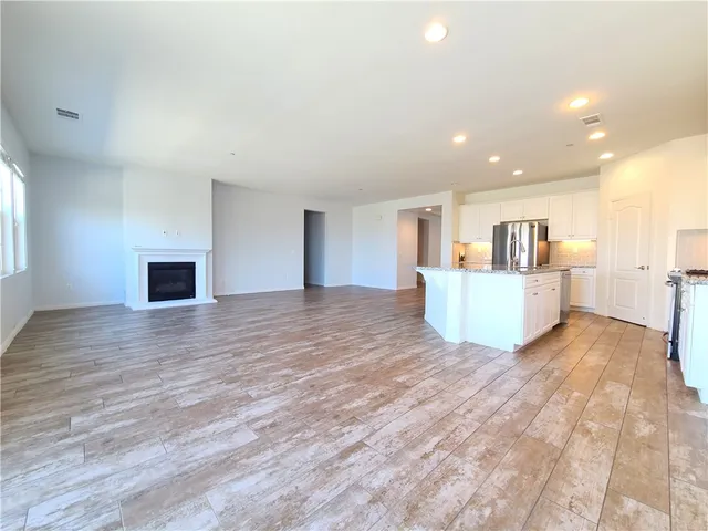 a view of a livingroom with a kitchen and a fireplace