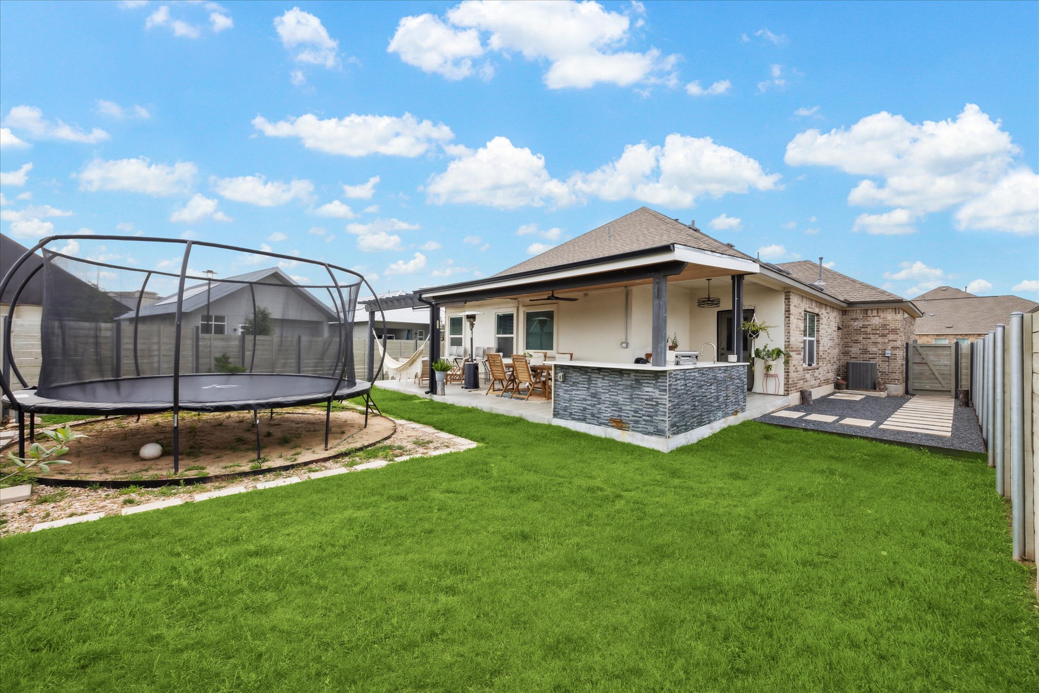 700 Legends Lane Georgetown, TX 78628 - Photo 29 of 31 Back of house featuring a trampoline, a patio, central AC unit, ceiling fan, and brick siding