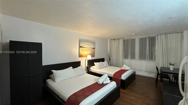 a bedroom with two beds and a chair