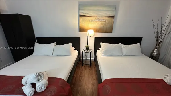 a bedroom with a bed and teddy bear on bed