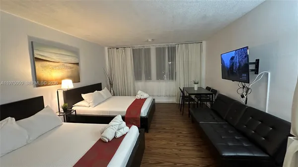 a bedroom with furniture and a flat screen tv