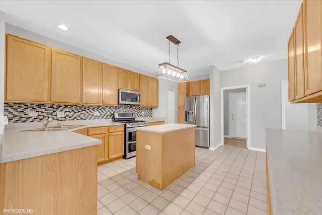 a kitchen with stainless steel appliances granite countertop a sink a stove and a refrigerator