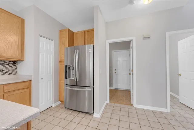 a view of a refrigerator in kitchen and white cabinets