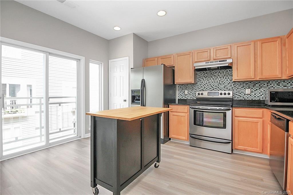 648 Raphael Place Charlotte, NC 28205 - Photo 13 of 48 a kitchen with stainless steel appliances white cabinets and wooden floor
