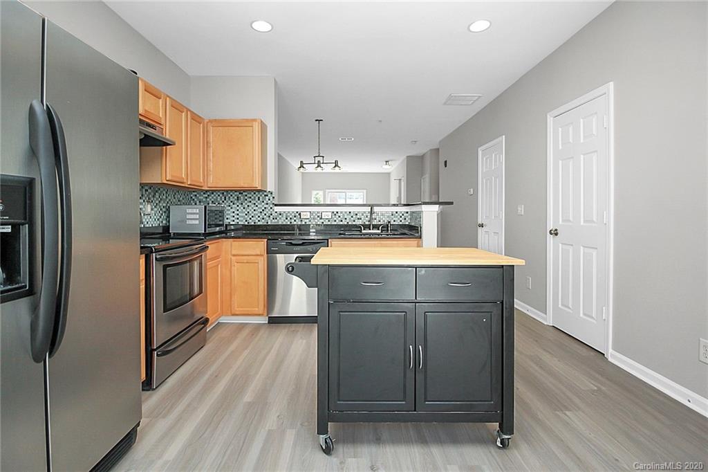 648 Raphael Place Charlotte, NC 28205 - Photo 16 of 48 a kitchen with stainless steel appliances granite countertop a refrigerator a stove and a sink with wooden floor