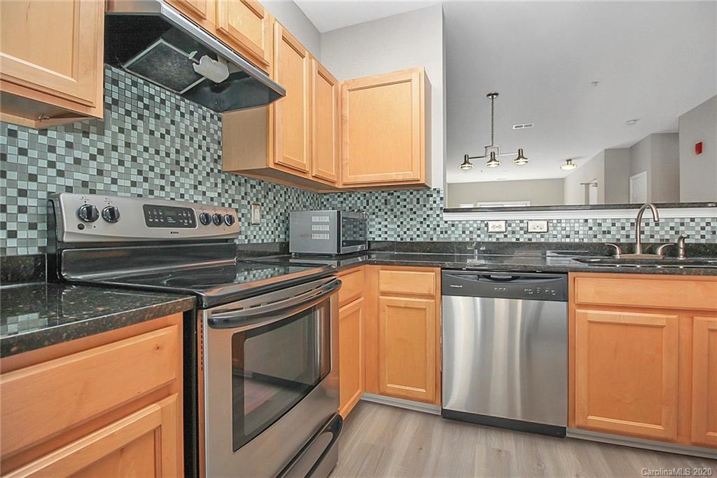 648 Raphael Place Charlotte, NC 28205 - Photo 18 of 48 a kitchen with stainless steel appliances granite countertop a stove and a sink