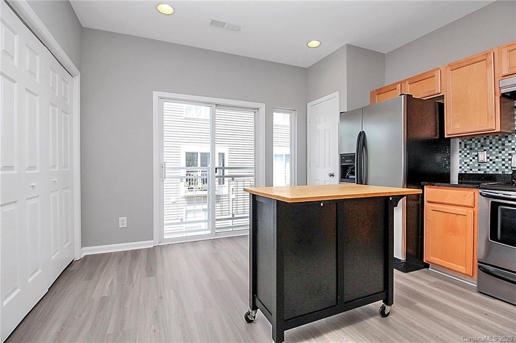 648 Raphael Place Charlotte, NC 28205 - Photo 26 of 48 a kitchen with stainless steel appliances a refrigerator and wooden floor