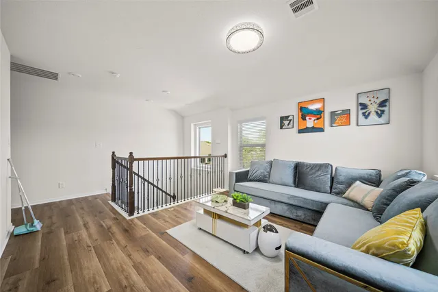 a living room with furniture and a wooden floor