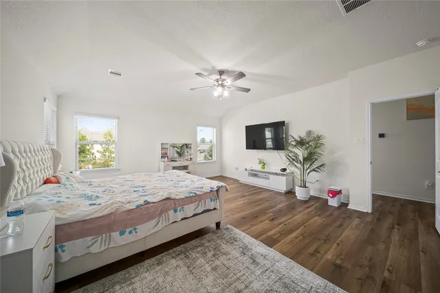 a bedroom with a bed chandelier and a flat screen tv