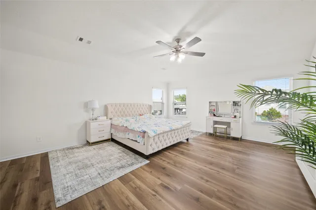 a spacious bedroom with a bed and a chandelier