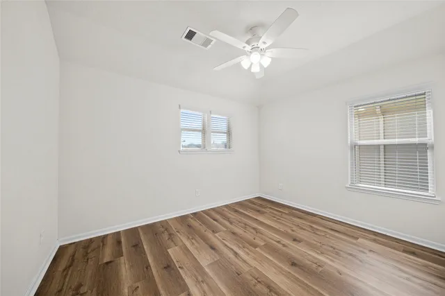 a view of a room with wooden floor and windows