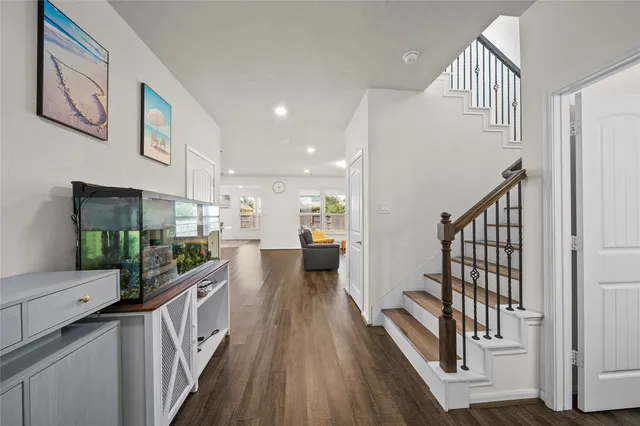 a view of a hallway with wooden floor and staircase