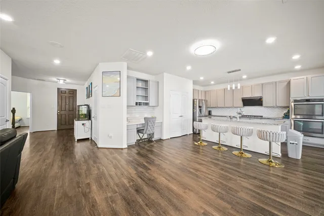 a view of kitchen with refrigerator microwave and wooden floor