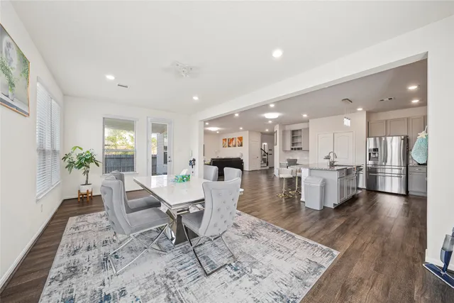 a view of a dining room and livingroom with furniture wooden floor and a rug