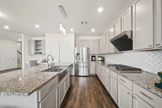a kitchen with stainless steel appliances granite countertop a sink stove and refrigerator
