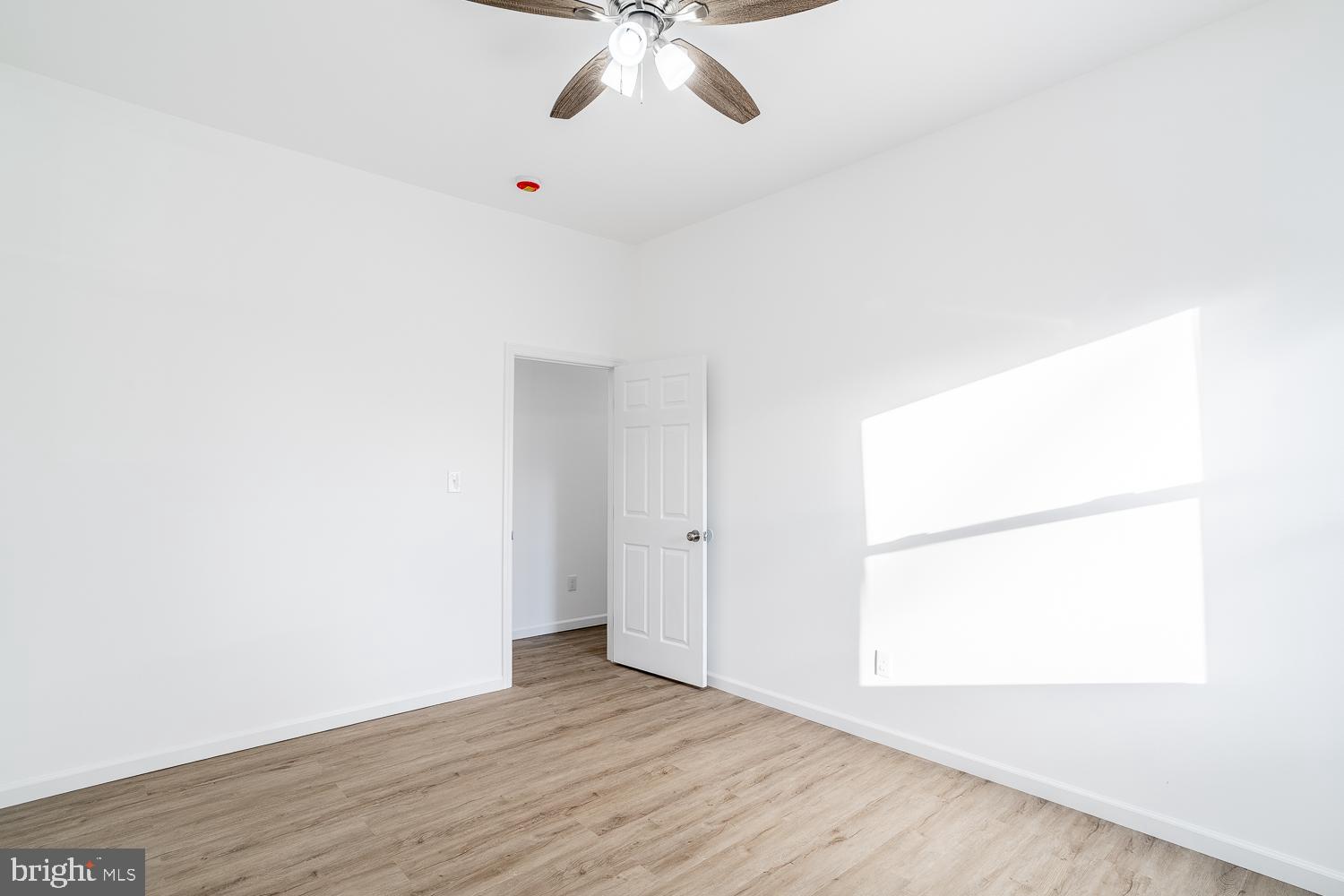 115 Hanover Street, Unit 4 Pemberton, NJ 08068 - Photo 11 of 14 an empty room with wooden floor chandelier fan and windows