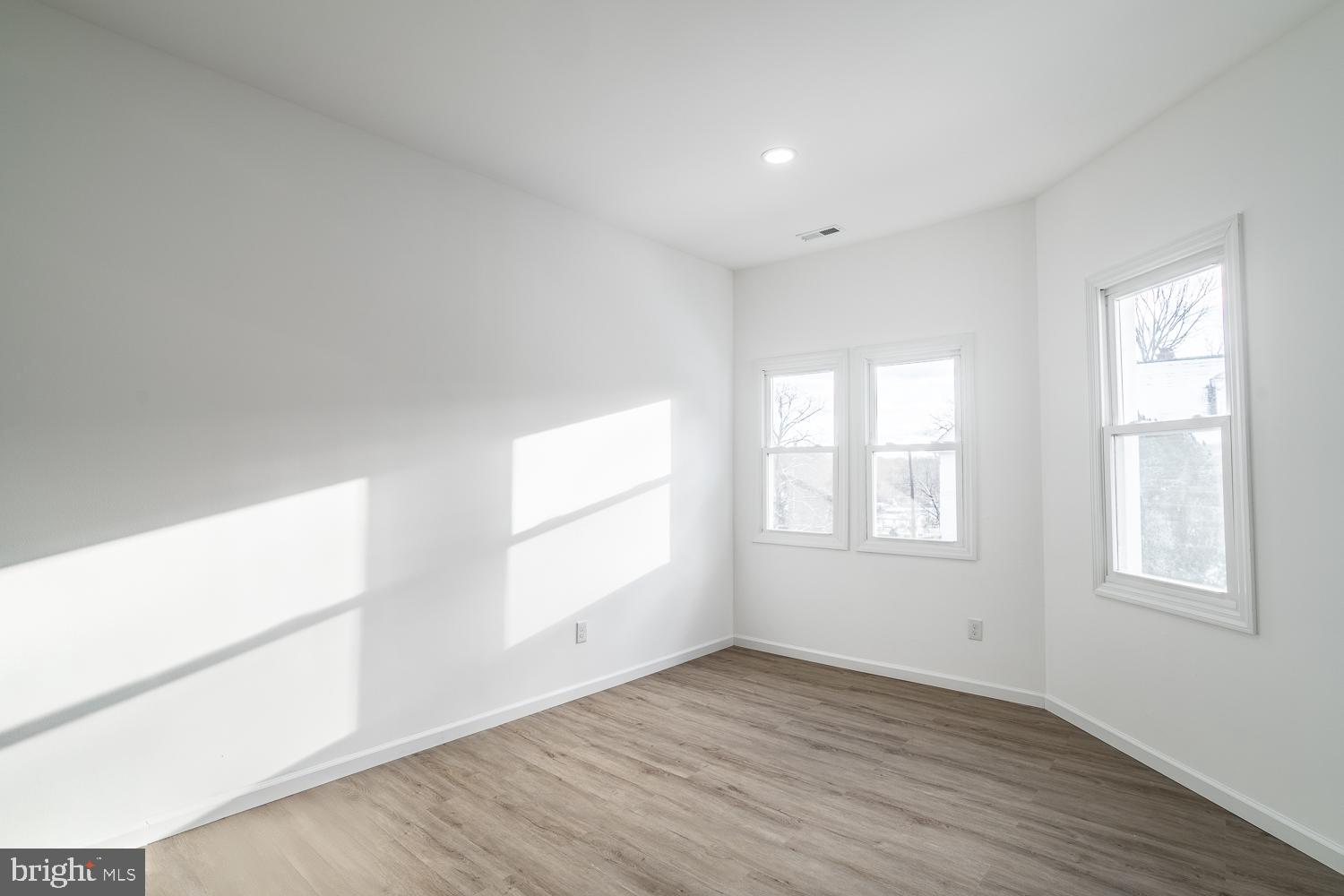 115 Hanover Street, Unit 4 Pemberton, NJ 08068 - Photo 3 of 14 an empty room with wooden floor and windows