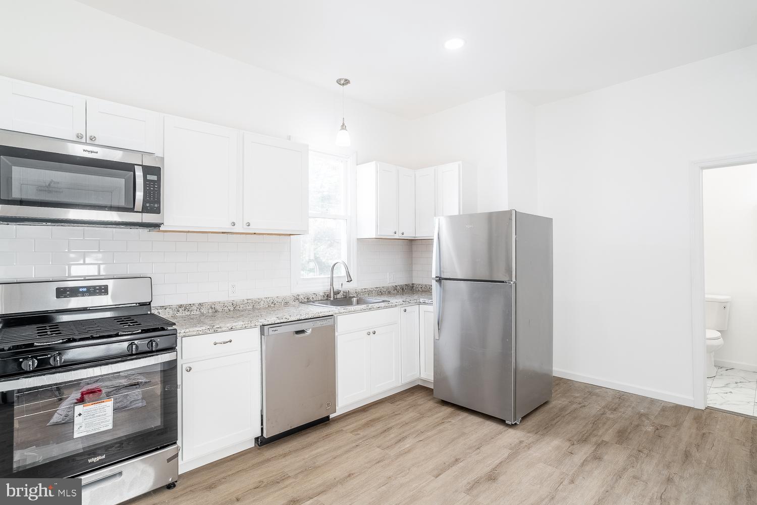 115 Hanover Street, Unit 4 Pemberton, NJ 08068 - Photo 4 of 14 a kitchen with stainless steel appliances a stove a sink and a microwave