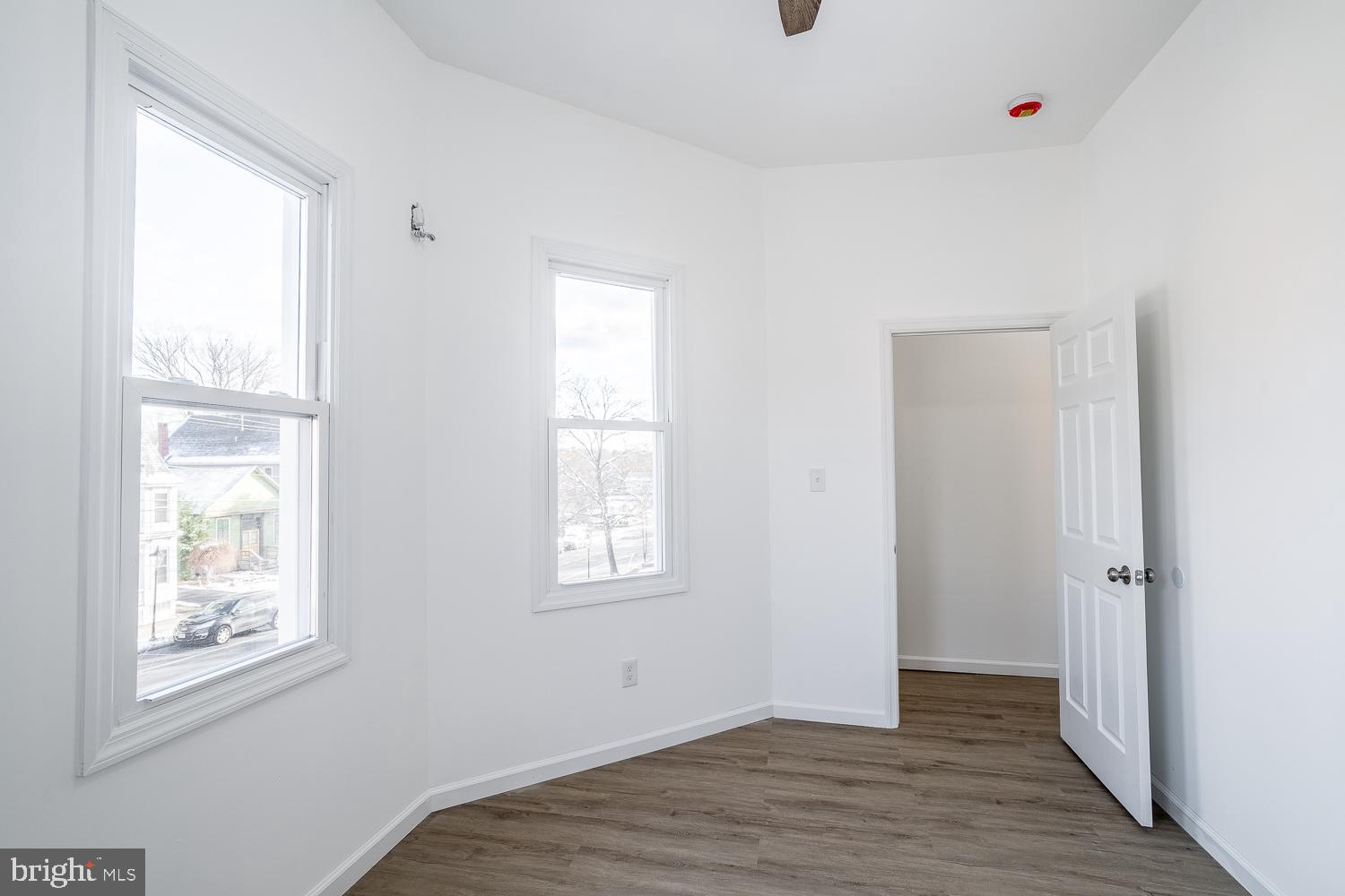 115 Hanover Street, Unit 4 Pemberton, NJ 08068 - Photo 7 of 14 a view of an empty room with wooden floor and a window
