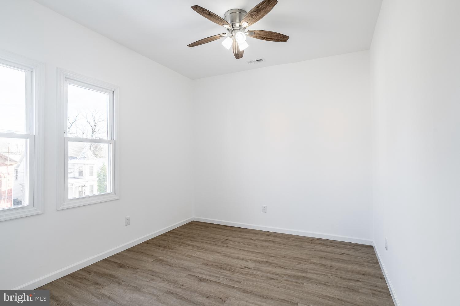 115 Hanover Street, Unit 4 Pemberton, NJ 08068 - Photo 8 of 14 an empty room with wooden floor fan and windows