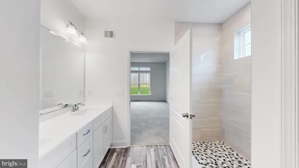 a bathroom with a double vanity sink a toilet and a shower
