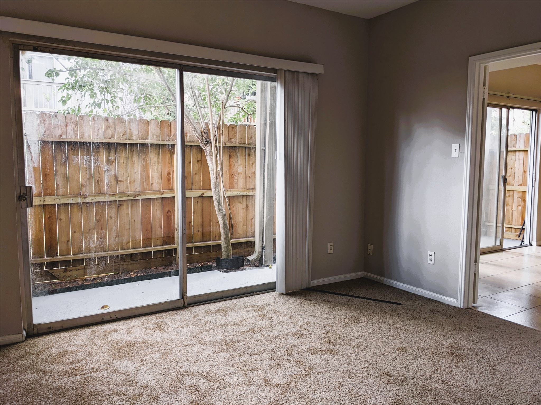 2100 Tanglewilde Street, Unit 421 Houston, TX 77063 - Photo 11 of 21 a view of an empty room with sliding glass door and wooden floor