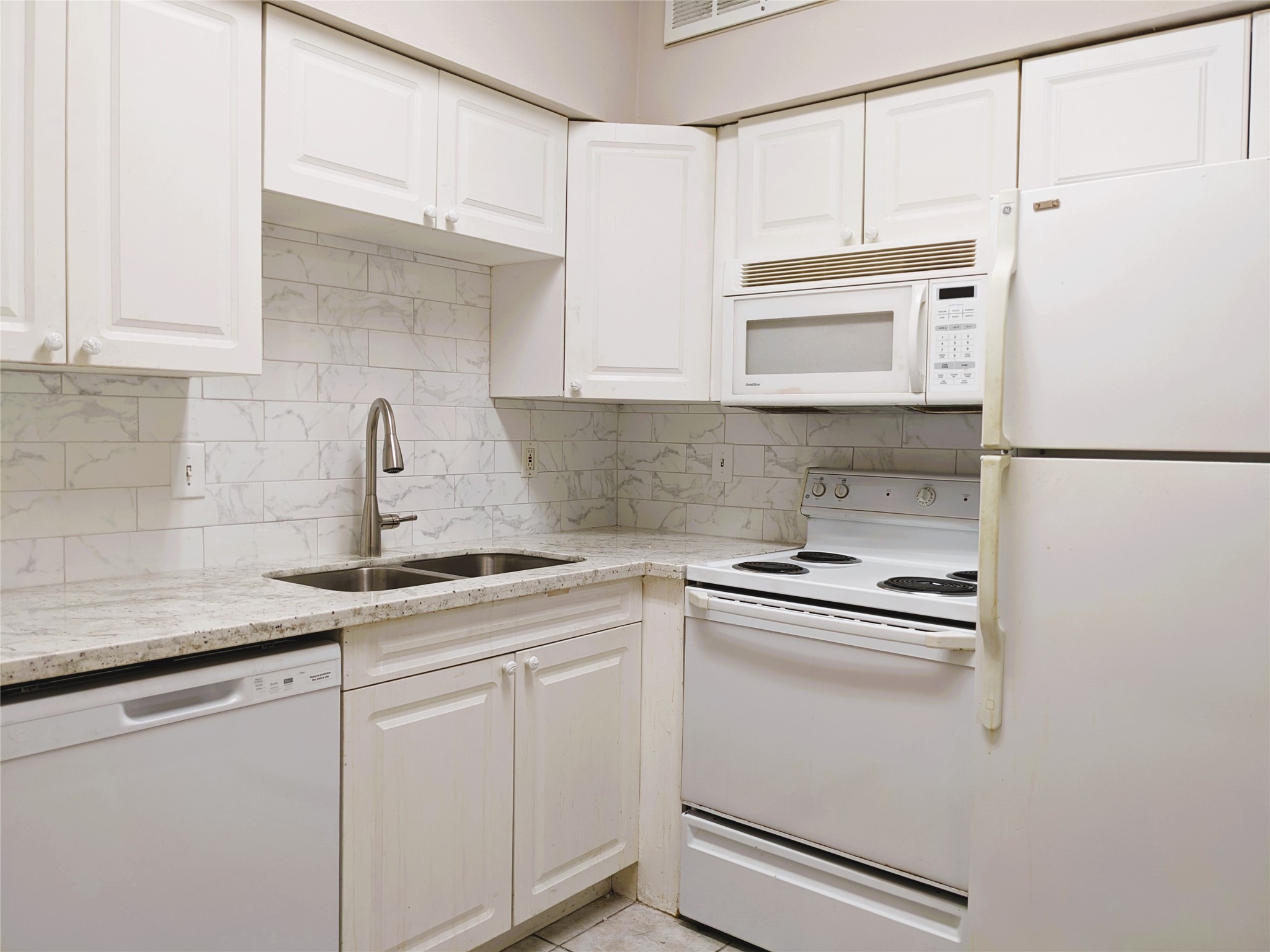 2100 Tanglewilde Street, Unit 421 Houston, TX 77063 - Photo 7 of 21 a kitchen with white cabinets and white appliances