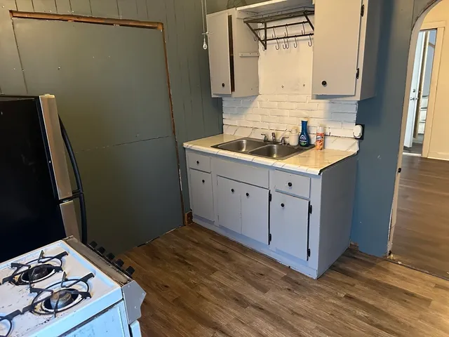 a kitchen with sink cabinets and wooden floor