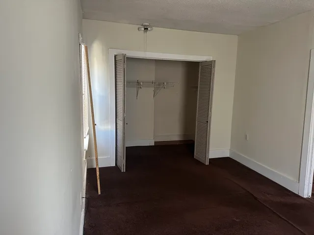 an empty room with wooden floor and closet