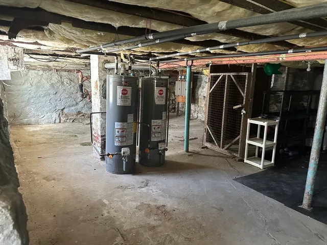 a view of water heater room with wooden floor
