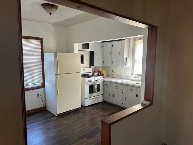 a kitchen with wooden cabinets and white appliances
