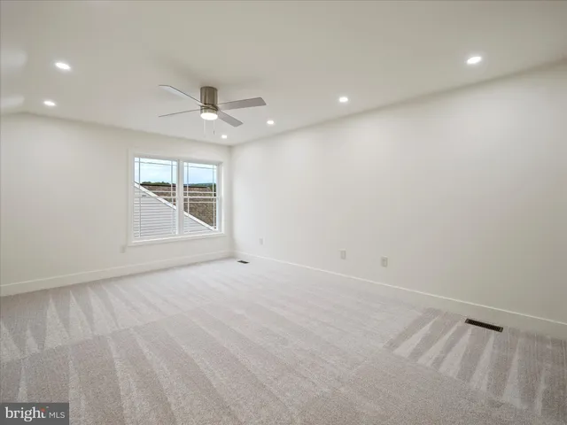 an empty room with an entryway and fan