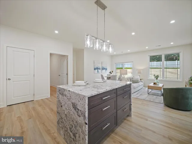 a kitchen with granite countertop a stove and a wooden floors
