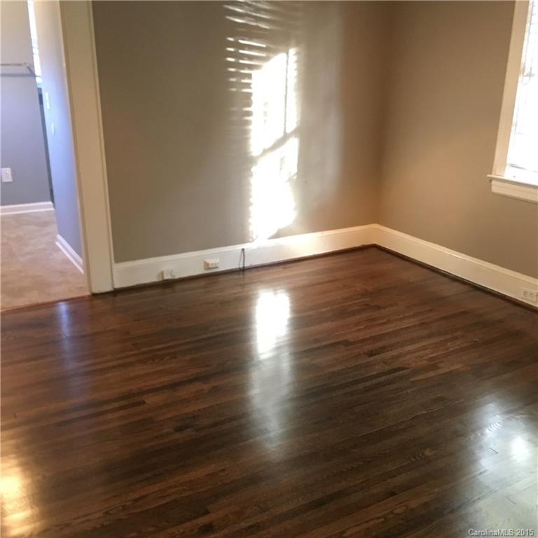 3719 Park Road Charlotte, NC 28209 - Photo 10 of 14 an empty room with wooden floor and windows with curtains