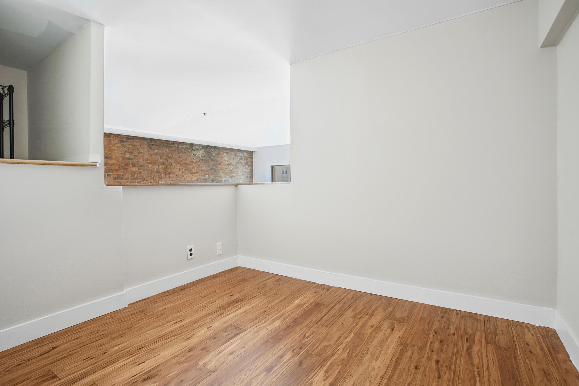 77 Bleecker Street, Unit 804 Manhattan, NY 10012 - Photo 6 of 12 a view of a room with wooden floor and white walls