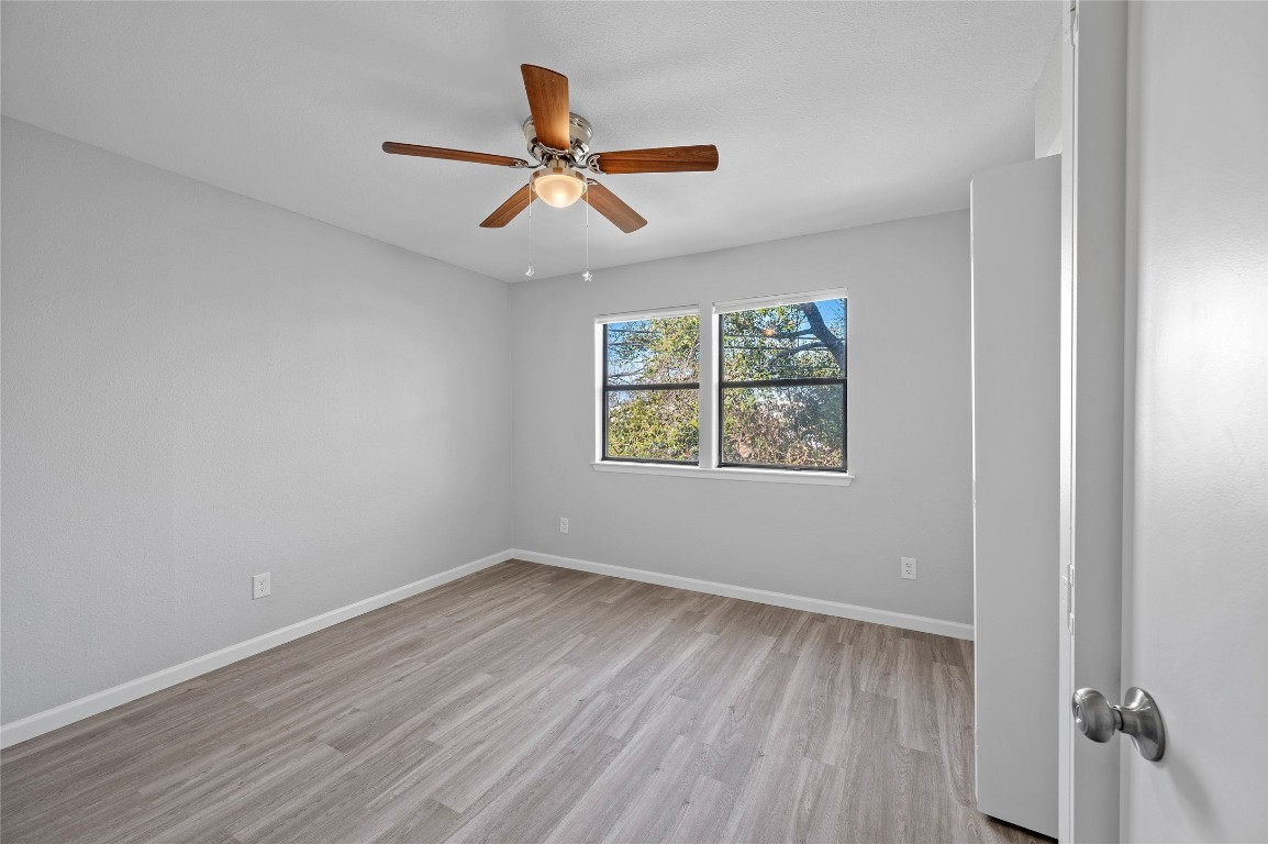11301 Jollyville Road, Unit B3 Austin, TX 78759 - Photo 16 of 21 an empty room with wooden floor ceiling fan and windows
