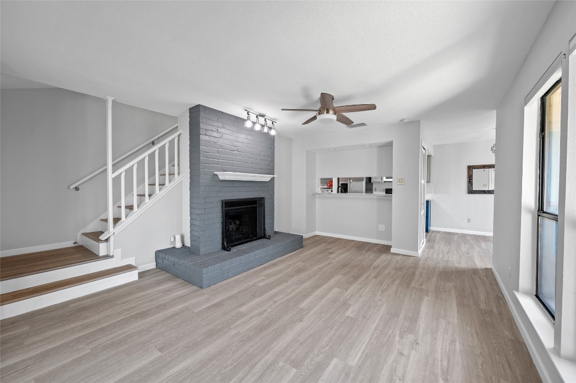 11301 Jollyville Road, Unit B3 Austin, TX 78759 - Photo 3 of 21 a view of a livingroom with wooden floor kitchen fireplace and staircase